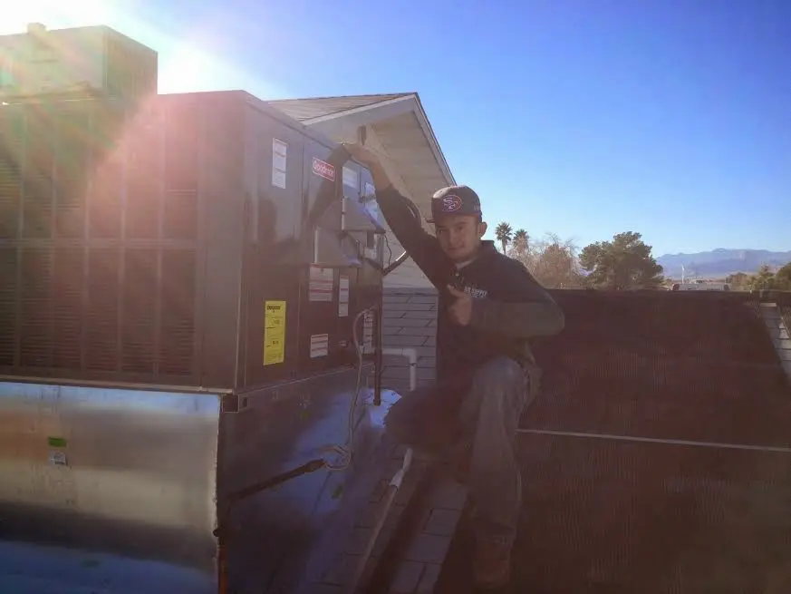 HVAC technician performing Heat Pump Repair on a rooftop unit in Whitehall